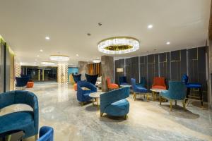 a lobby with blue and orange chairs and tables at Hotel Nalanda in Ahmedabad