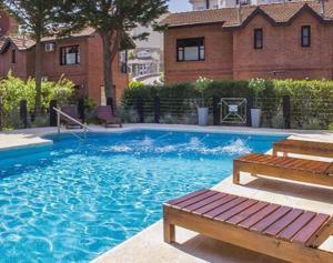 a swimming pool with a bench and a house at DUPLEX Casa 100 m2 CARILO HOUSE Complejo Residencial Sin Serv in Carilo