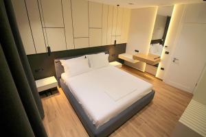 Un dormitorio con una gran cama blanca y un espejo. en "The View" Luxury Apartments, en Sarandë
