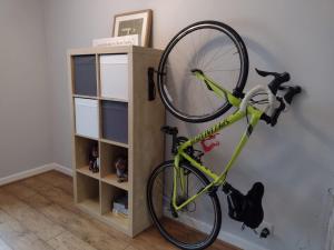 a bike hanging on a wall next to a book shelf at Ty Collective - Near Town Centre in Dowlais