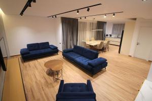 Una sala de estar con dos sofás azules y una mesa. en "The View" Luxury Apartments, en Sarandë