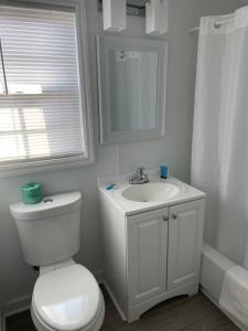 a white bathroom with a toilet and a sink at Sunburst Hotel in Myrtle Beach +16 photos