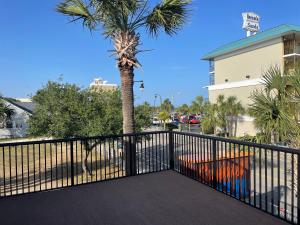 a balcony with a black fence and a palm tree at Sunburst Hotel in Myrtle Beach