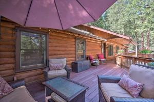a porch of a cabin with chairs and an umbrella at Pollock Pines Resort Cabin 11 Mi to Apple Hill in Pollock Pines