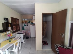 Habitación con cocina con mesa y puerta. en Cantinho Morro Branco en Beberibe