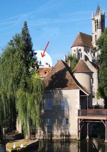 ein Gebäude mit einem roten Pfeil, der auf eine Kirche zeigt in der Unterkunft Atelier d'Art - vue panoramique in Moret-sur-Loing
