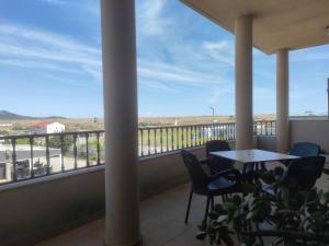 d'un balcon avec une table et des chaises et une vue. dans l'établissement Hostal Parador de los Llanos, à Torreorgaz