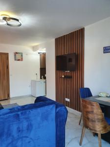 Una sala de estar con un sofá azul y una mesa. en Apartmani Parice, en Novi Pazar
