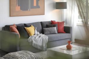 a living room with a gray couch with colorful pillows at Cascais Sun Apartment in Cascais