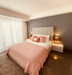 um quarto com uma cama grande e almofadas cor-de-rosa em Cascais Sun Apartment em Cascais