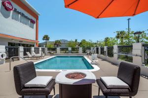 a pool with chairs and a table and an umbrella at Best Western Plus Panama City Hotel in Panama City