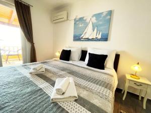 a bedroom with a large bed with a sailboat painting on the wall at Apartments Sunset in Mlini