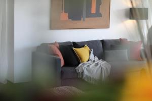 a living room with a gray couch with pillows at Cascais Sun Apartment in Cascais