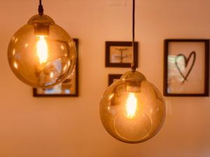 two lights hanging from a wall with pictures at Cascais Sun Apartment in Cascais