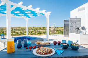a blue table with food and drinks on a patio at Santa Marina Milos in Mytakas