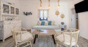a bedroom with a bed and two chairs and a table at Santa Marina Milos in Mytakas +26 photos
