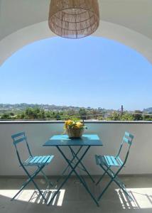 einen Tisch mit 2 Stühlen und eine Obstschale auf dem Balkon in der Unterkunft Teresa Madre in Procida