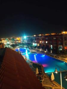 Porto Matruh - Your Family's Peaceful Summer Stay في مرسى مطروح: مسبح كبير في الليل في مدينة