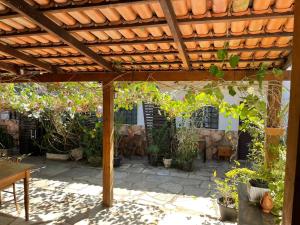 un patio con pérgola de madera y muchas plantas en Pouso do Rio en Pirenópolis