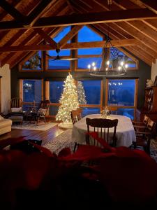 a living room with a christmas tree and a table at The Blue House On The Hill Catskills—Views in Claryville
