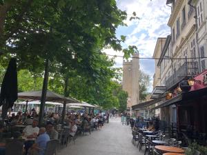 a group of people sitting at tables in a street at La Pignotte in Avignon