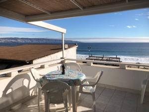 a table and chairs on a balcony with a view of the ocean at Sunset View in Viña del Mar
