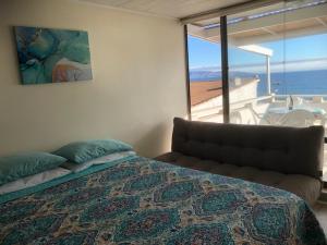a bedroom with a bed and a view of the ocean at Sunset View in Viña del Mar