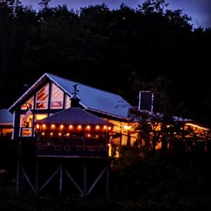 a gazebo with lights in front of a house at night at The Blue House On The Hill Catskills—Views in Claryville