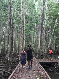 a man and woman walking on a bridge in the woods at TABARI DIVE LODGE in Pulau Mansuar