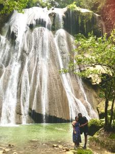 two people standing in front of a waterfall at TABARI DIVE LODGE in Pulau Mansuar