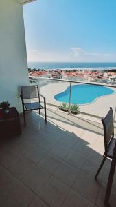 een balkon met 2 stoelen en een zwembad bij Brisa do Mar Ap. in Nazaré