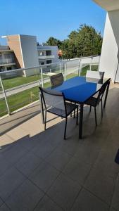 een blauwe tafel en 2 stoelen op een balkon bij Brisa do Mar Ap. in Nazaré