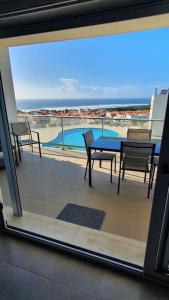 Habitación con vistas a un balcón con mesa y sillas. en Brisa do Mar Ap., en Nazaré