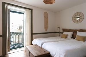 two beds in a room with a balcony at Casa da Praça - Guest House in Pinhel