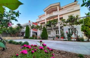 a building with pink flowers in front of it at Apartments Perezaj in Ulcinj