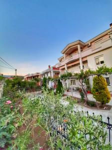 a building with a garden in front of it at Apartments Perezaj in Ulcinj