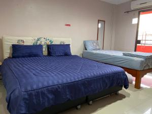 a bedroom with two beds with blue pillows at SMILE HOME GUESTHOUSE in Rayong