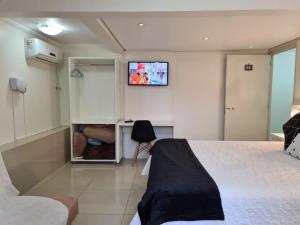 - une chambre avec un lit et une télévision murale dans l'établissement Edelweiss Haus, à Feliz