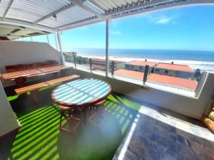 d'un balcon avec une table et une vue sur la plage. dans l'établissement Beach Splendor @ 24 La Crete Sands, à Margate