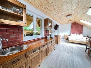 eine Küche mit Spüle und Ziegelwand in der Unterkunft PENSION POD SKALOU in Hřensko