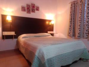 Altas Mareas 2 في لاس غروتاس: غرفة نوم بسرير في غرفة بها مصباحين