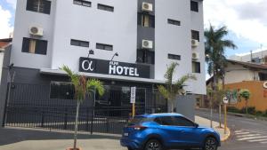 a blue car parked in front of a hotel at Hotel Alfa de Bauru Ltda in Bauru