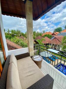 a balcony with a couch and a view of the ocean at Radya Homestay in Nusa Lembongan