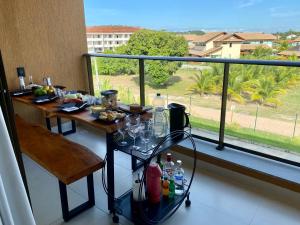 einen Balkon mit einem Tisch mit Speisen und Getränken in der Unterkunft Luxuoso Apt Eco Resort- Beira mar Praia Carneiros in Rio Formoso