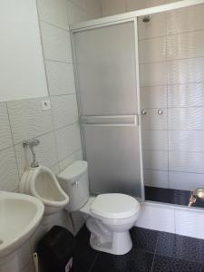 a bathroom with a white toilet and a sink at Ecolodge Casa del Montañista in Huaraz