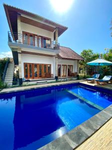 a house with a swimming pool in front of a house at Radya Homestay in Nusa Lembongan