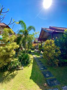 a garden with a pathway leading to a house at Radya Homestay in Nusa Lembongan