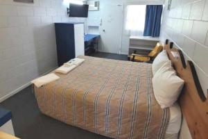 a person laying on a bed in a room at Innisfail City Motel in Innisfail