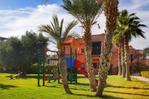 un parque infantil con palmeras en Duplex Atlas Golf Resort Pοοl νieω Seriniτყ & Cαlm, en Marrakech