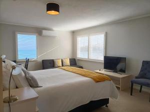 布拉夫的住宿－Lands End，一间卧室配有一张床、一张书桌和一台电视